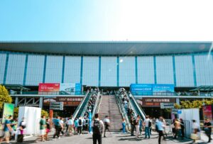 People entering Shanghai exhibition center via outdoor escalator during daytime.