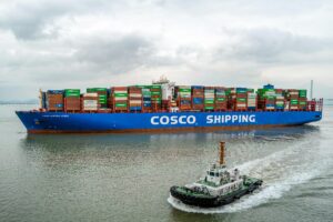 A large COSCO container ship navigates the waters of Ningbo Harbor, China.
