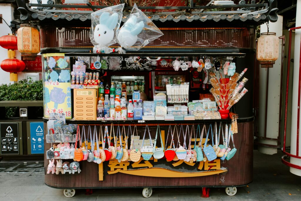 Vibrant street vendor stall in Nanjing, China selling snacks and toys.